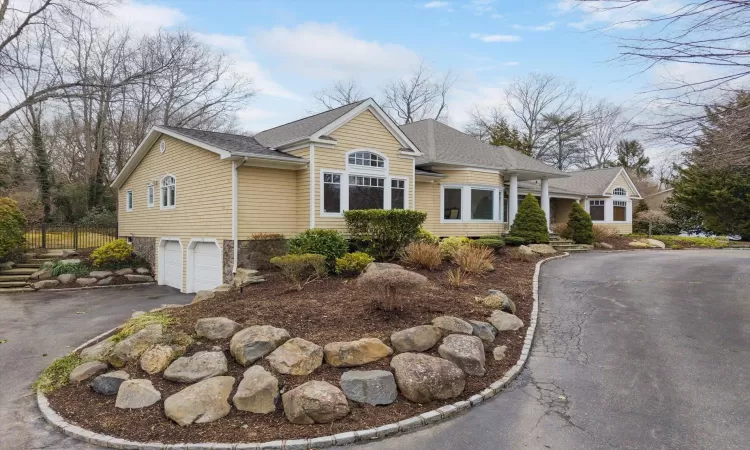 View of front of property with aphalt driveway, fence, a garage, and a shingled roof