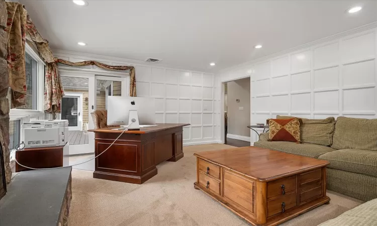 Office area featuring visible vents, light carpet, ornamental molding, recessed lighting, and a decorative wall