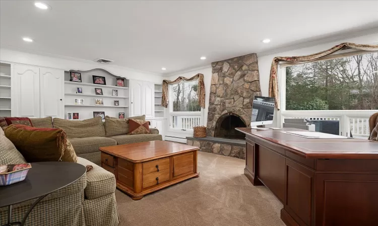 Living area featuring visible vents, ornamental molding, a stone fireplace, recessed lighting, and a baseboard radiator