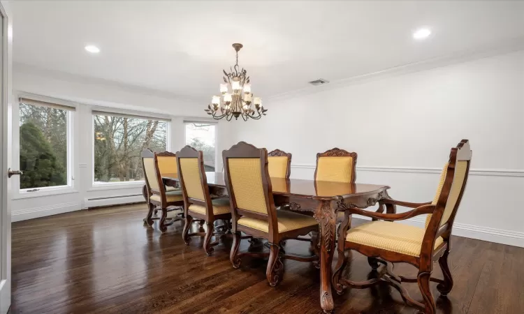 Dining area featuring crown molding, recessed lighting, and dark wood-style floors