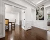 Dining room with recessed lighting, ornamental molding, dark wood-type flooring, a baseboard heating unit, and a decorative wall