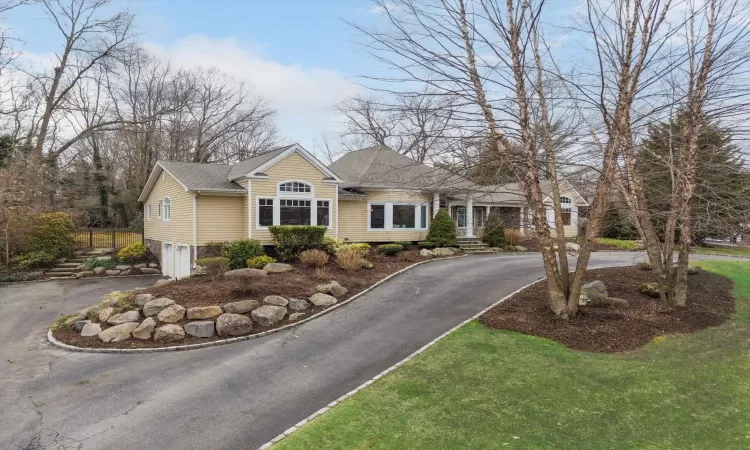 View of front of house featuring a garage, roof with shingles, and driveway