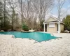 View of swimming pool with an outdoor structure, a storage structure, a patio area, and a fenced in pool