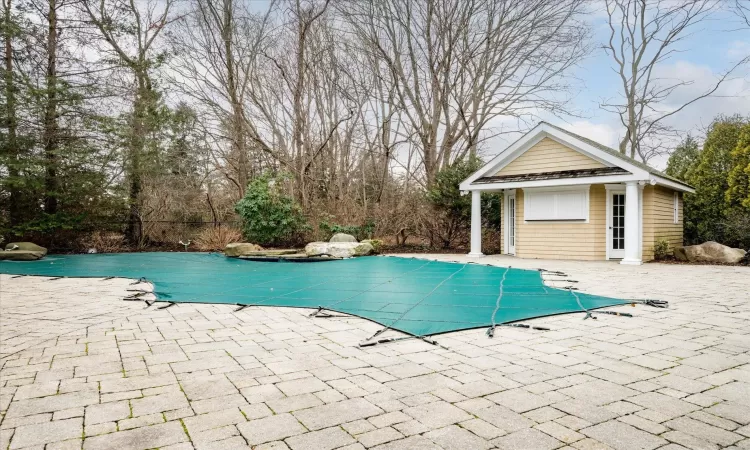 View of swimming pool with an outdoor structure, a storage structure, a patio area, and a fenced in pool