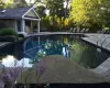 Outdoor pool with an exterior structure, an outdoor structure, and a patio