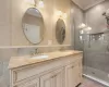 Bathroom with crown molding, a shower stall, and a sink