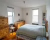 Bedroom with wood finished floors and radiator heating unit