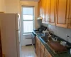 Kitchen featuring dark countertops, gas stove, freestanding refrigerator, and a sink