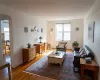 Living area with arched walkways, plenty of natural light, and wood finished floors