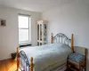 Bedroom with radiator, baseboards, and hardwood / wood-style floors