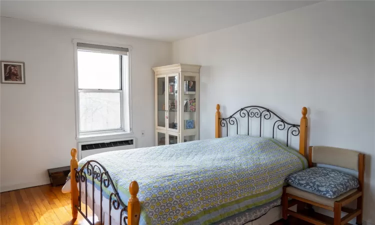 Bedroom with radiator, baseboards, and hardwood / wood-style floors