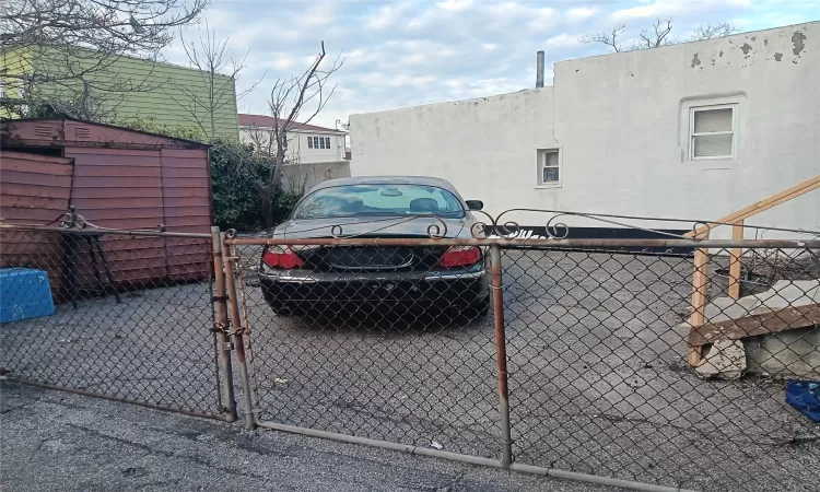 View of parking featuring a gate and fence