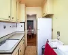 Kitchen with cream cabinetry, a sink, tasteful backsplash, freestanding refrigerator, and light floors