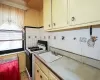 Kitchen with light floors, gas range gas stove, a sink, decorative backsplash, and light countertops