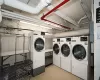 Shared laundry area with washer and dryer and light floors