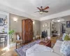 Living area featuring a ceiling fan, arched walkways, and baseboards