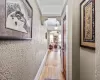 Hallway featuring baseboards, arched walkways, wood finished floors, and a textured wall