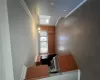 Kitchen with baseboards, a chandelier, ornamental molding, brown cabinetry, and fridge