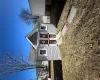 View of front facade with an outbuilding, a storage shed, a front yard, and roof with shingles