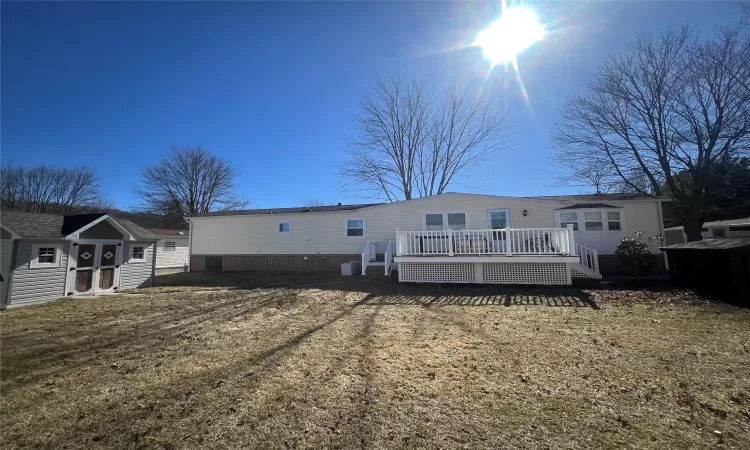 Back of property featuring a deck and an outdoor structure