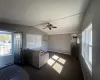 Unfurnished living room featuring vaulted ceiling, visible vents, baseboards, and ceiling fan