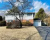 View of front of property with brick siding, an attached garage, driveway, and fence