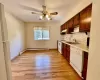 Kitchen featuring white appliances, a sink, light countertops, light wood-style floors, and under cabinet range hood