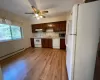 Kitchen with under cabinet range hood, a sink, backsplash, white appliances, and light countertops