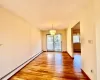 Unfurnished dining area with a notable chandelier, light wood-style flooring, a baseboard heating unit, and baseboards