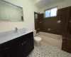 Bathroom featuring tile patterned flooring, toilet, vanity, and  shower combination