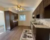 Kitchen featuring electric stove, a sink, dark brown cabinetry, light countertops, and a baseboard radiator