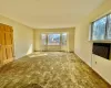 Carpeted empty room featuring heating unit, a baseboard heating unit, and baseboards