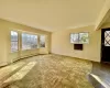 Unfurnished living room with a baseboard heating unit, plenty of natural light, and baseboards