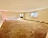 Carpeted empty room featuring a baseboard heating unit, a healthy amount of sunlight, and a textured ceiling