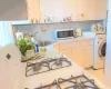 Kitchen with white microwave, washer / clothes dryer, a sink, light countertops, and backsplash