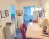 Dining room with dark colored carpet, a chandelier, and a wall mounted AC