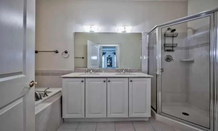 Full bathroom featuring a sink, a stall shower, and tile patterned flooring