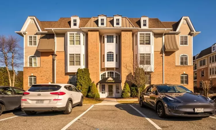 View of building exterior with uncovered parking