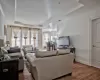 Living room featuring a tray ceiling, a healthy amount of sunlight, and wood finished floors