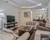 Living area featuring visible vents, wood finished floors, baseboards, crown molding, and a raised ceiling