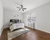 Bedroom with ceiling fan, baseboards, radiator, and wood finished floors