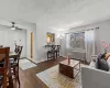 Living room featuring a textured ceiling, hardwood / wood-style floors, radiator, baseboards, and ceiling fan