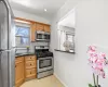 Kitchen featuring decorative backsplash, a healthy amount of sunlight, appliances with stainless steel finishes, and baseboards