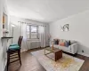 Living area with radiator, a textured ceiling, baseboards, and hardwood / wood-style floors