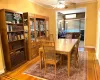 Dining area with hardwood / wood-style floors, an AC wall unit, ornamental molding, and a ceiling fan