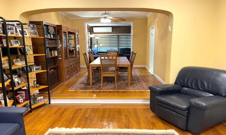 Dining space with hardwood / wood-style flooring, an AC wall unit, arched walkways, and ornamental molding