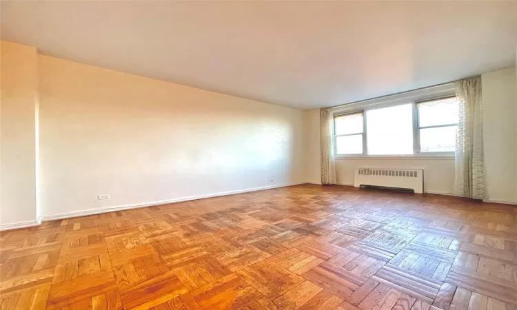 Empty room with radiator and baseboards