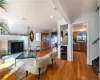 Living area featuring light wood finished floors, visible vents, radiator, wine cooler, and a premium fireplace