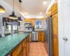 Kitchen featuring dark countertops, decorative backsplash, stainless steel appliances, and light tile patterned floors