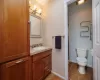 Primary Bathroom with tile patterned flooring, baseboards, toilet, a stall shower, and vanity